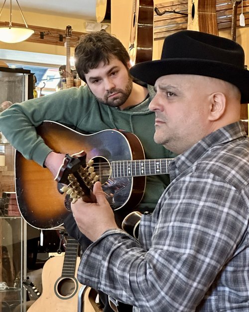Frank Solivan of "Dirty Kitchen" &nbsp;gives Alex Patrick a demonstration of his new flat picks. ...