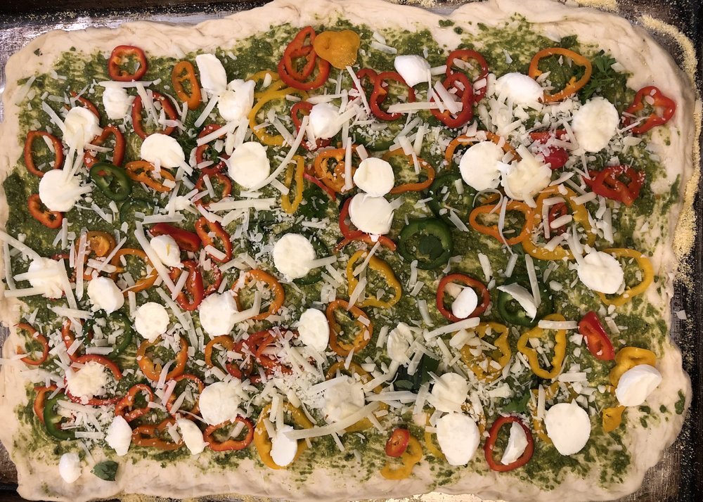 Pesto sauce, baby mozzarella, shredded Asiago, multi colored sweet peppers and capers.