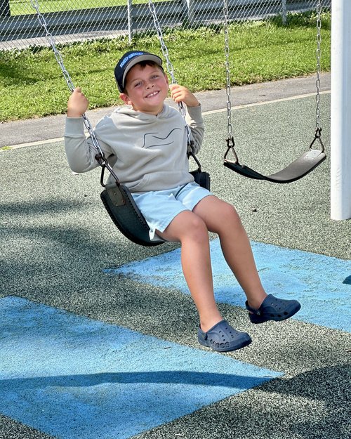 Testing out the swing at the elementary school playground