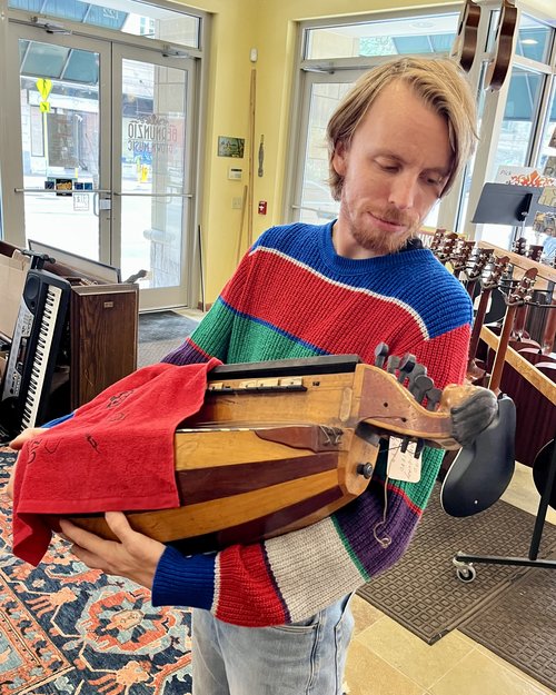 Sammy Hirsh cradles one of two 19th century French hurdy gurdies which are part of the collection.