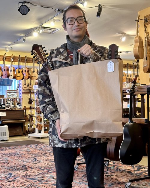 Some shoppers coming to Bernunzio Uptown Music and buy bags of mandolins!